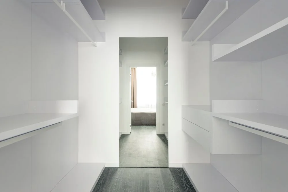 Organized minimalist walk-in closet representing systematic care